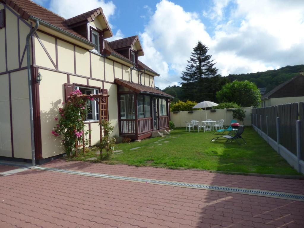 une maison avec une terrasse et une cour dans l'établissement Gîte Le Petit Chalet avec parking gratuit, à Étretat