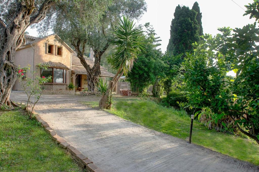 eine Auffahrt zu einem Haus mit Bäumen in der Unterkunft Villa Brigadoon Corfu in Agios Ioannis Peristerion