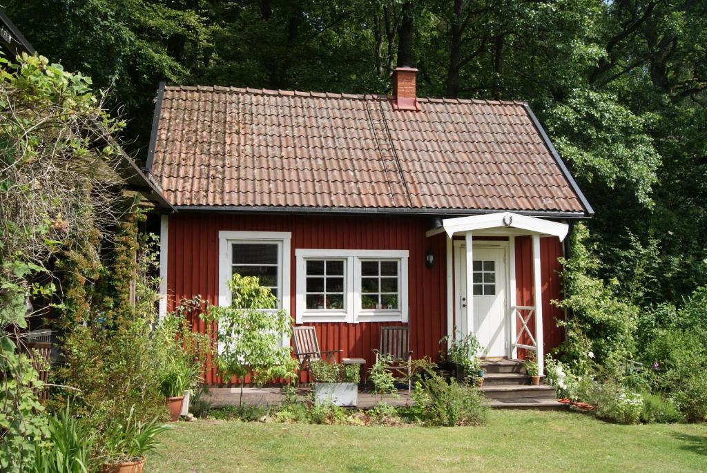 une petite maison rouge avec une porte blanche dans l'établissement Sövröds Hage, à Höör