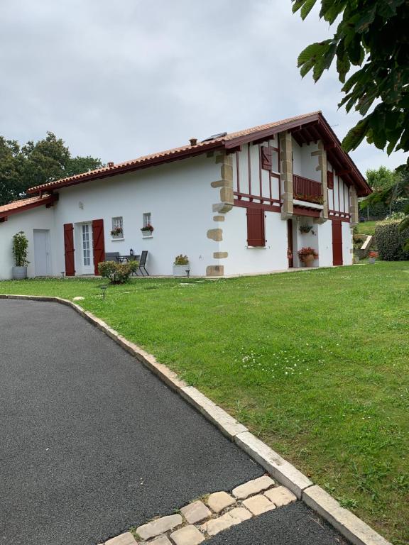 a white house with a road in front of it at Villa Les Hortensias B&B in Arcangues