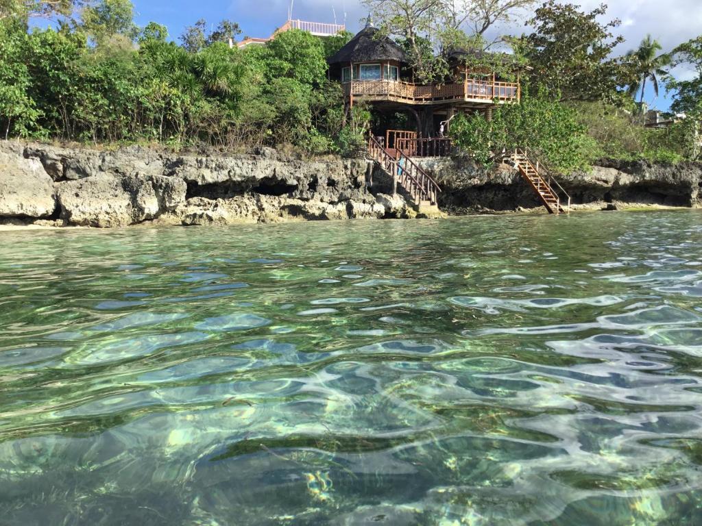 a house on the shore of a body of water at Sun & Sea Home Stay in Camotes Islands