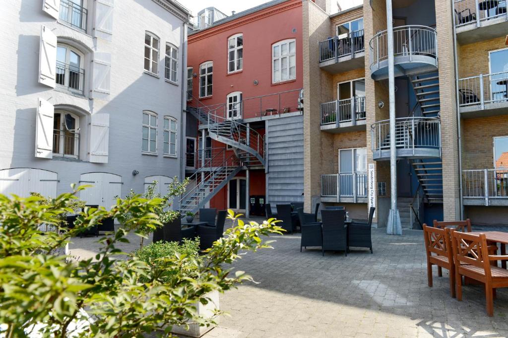 a courtyard of apartment buildings with tables and chairs at Sønderborg City Apartments in Sønderborg