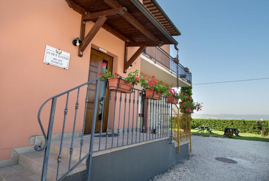 un bâtiment avec des plantes en pot sur un balcon dans l'établissement Bed & Breakfast Al Pian d'Assisi, à Assise