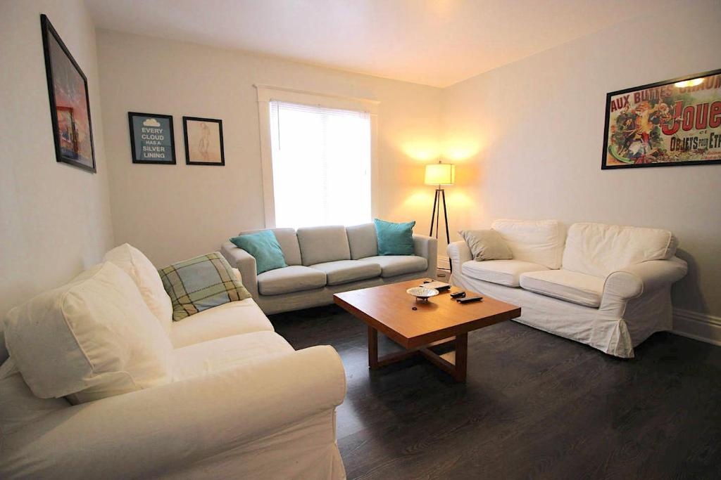 ein Wohnzimmer mit 2 weißen Sofas und einem Couchtisch in der Unterkunft Maison Doucet in Niagara Falls