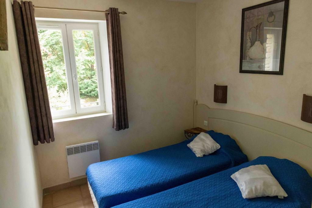 1 dormitorio con 2 camas y ventana en Gordes Le Bastidon, en Gordes