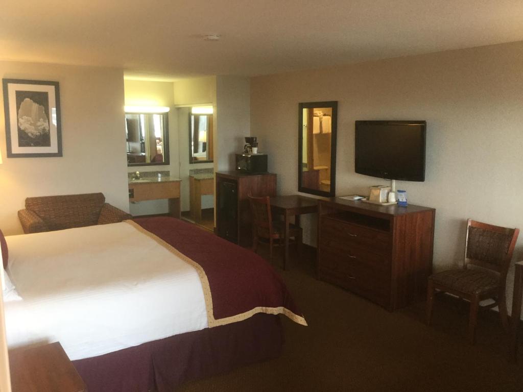 a hotel room with a bed and a flat screen tv at Baymont by Wyndham Cortez in Cortez