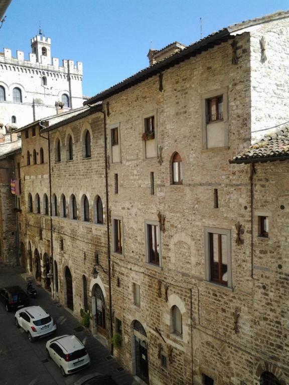 an old brick building with cars parked in front of it at Appartamento Galeotti 18 in Gubbio