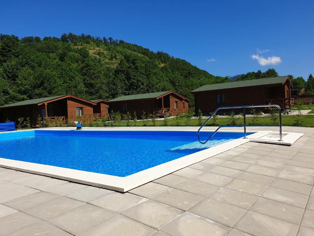 a swimming pool in a yard with houses in the background at Kalabash Apartments in Sovata