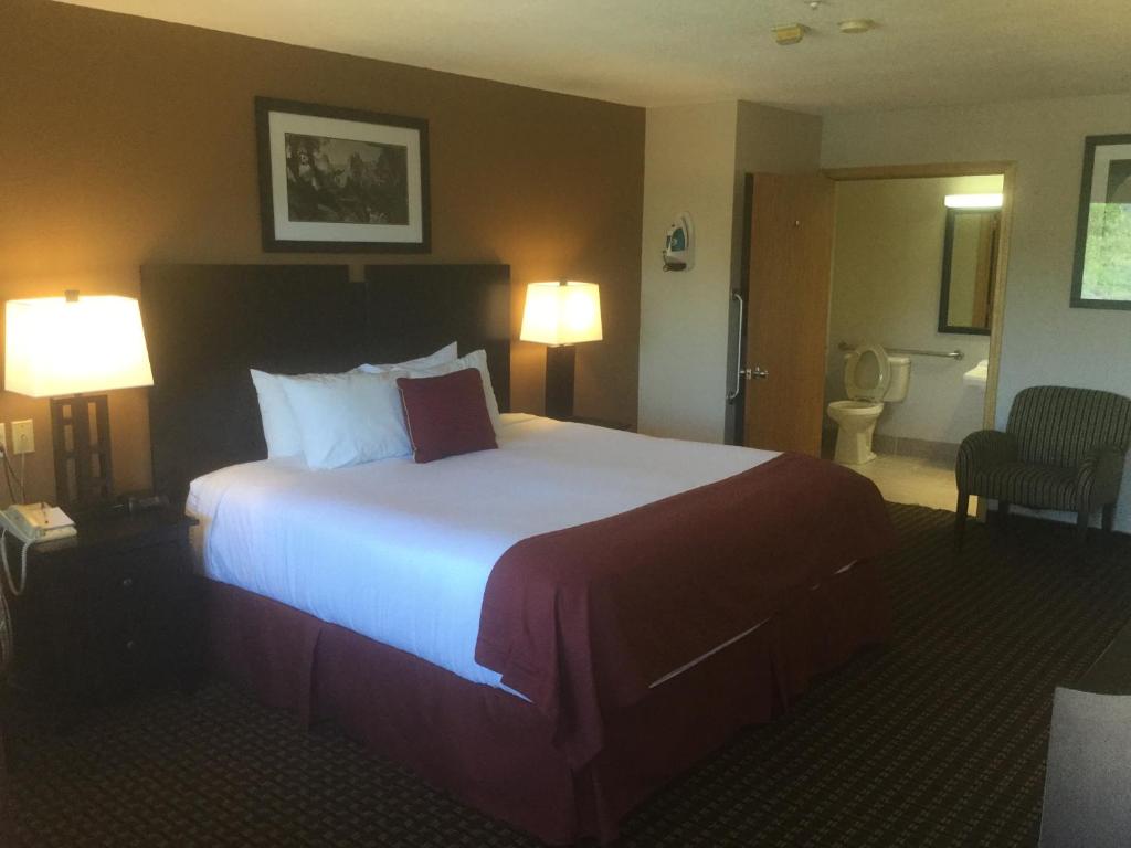 a hotel room with a large bed and two lamps at Baymont by Wyndham Cortez in Cortez