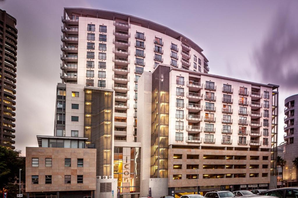 a tall white building with cars parked in front of it at Icon Serviced Apartments Foreshore in Cape Town
