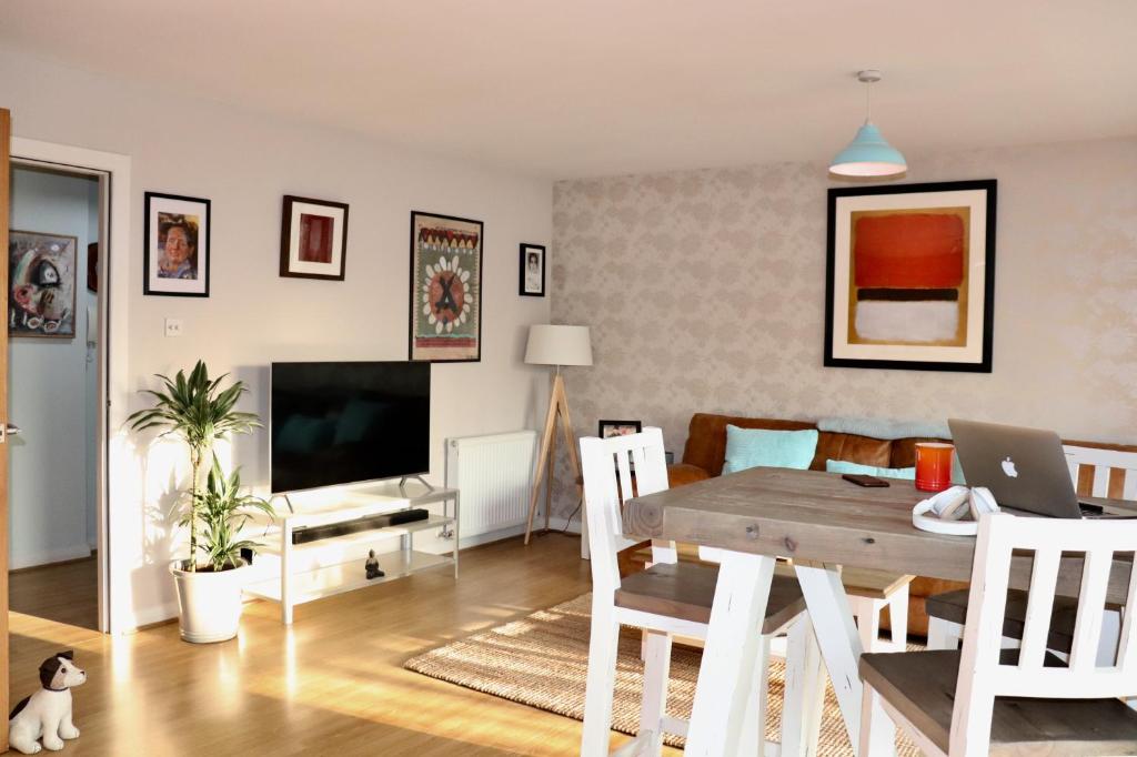 a living room with a dining room table with a laptop at LuxApartment - Port Of Leith - Free Parking in Edinburgh