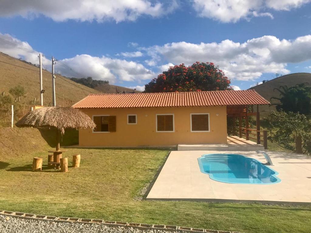 una pequeña casa con piscina en el patio en Casa de campo en Petrópolis