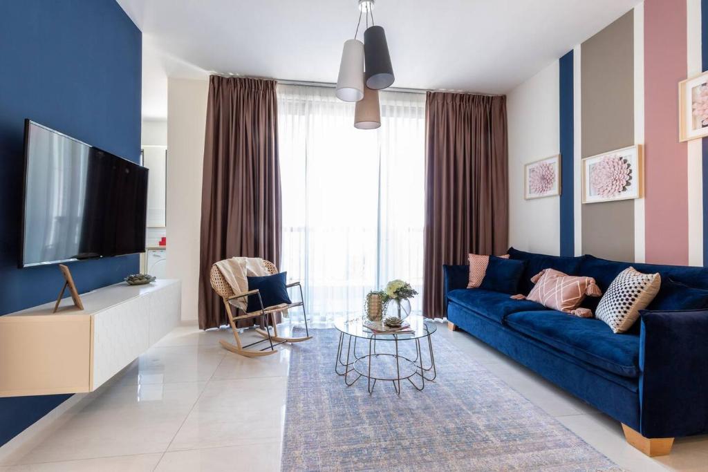 a living room with a blue couch and a tv at Magical 3BR/Parking with amazing view, city center in Jerusalem