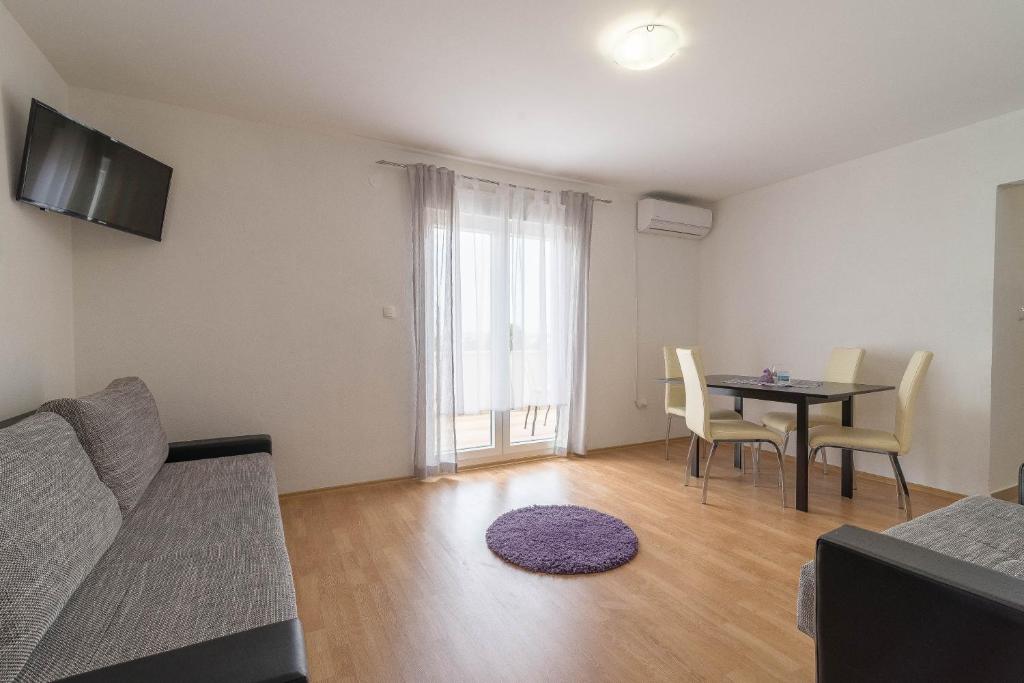 een woonkamer met een bank en een eettafel bij Apartment Summer in Sukošan