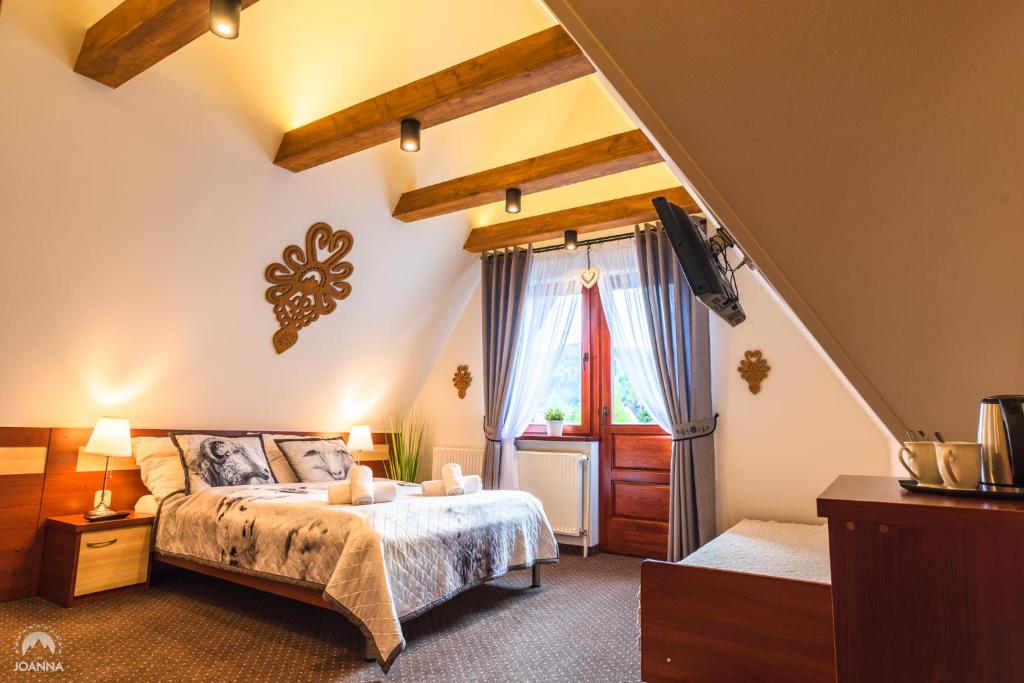 um quarto com uma cama e uma janela em Willa Joanna em Zakopane