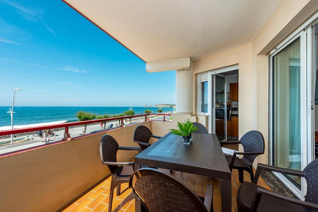 balcone con tavolo, sedie e vista sull'oceano di Première ligne de plage, face à la mer a Hendaye