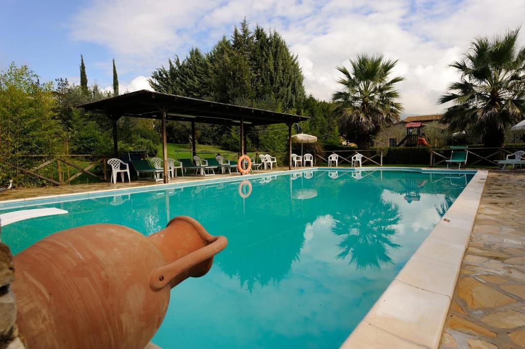 una grande piscina con sedie e gazebo di Country House Il Piancardato a Collazzone
