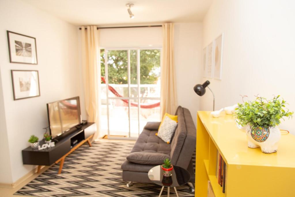 a living room with a couch and a tv at Apartamento Aclimação by OBA in Sao Paulo