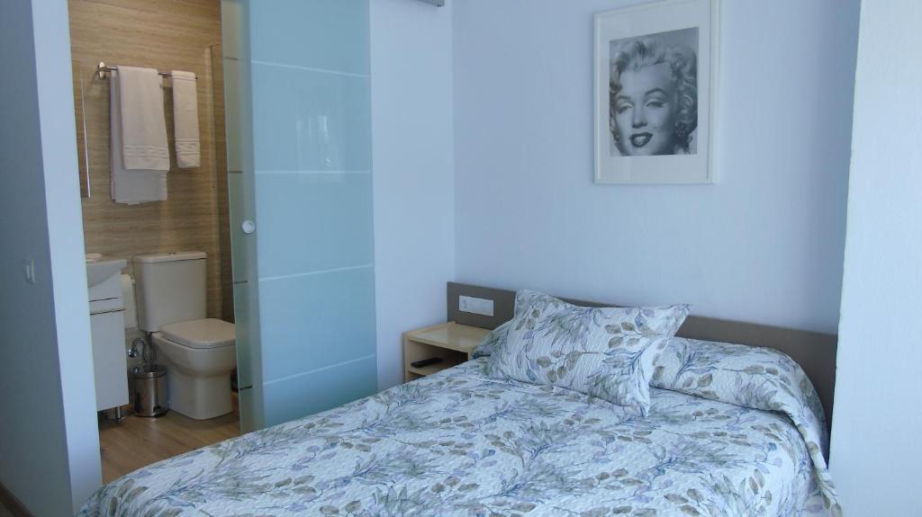 a small bedroom with a bed and a bathroom at PENSION OVIEDO in Oviedo