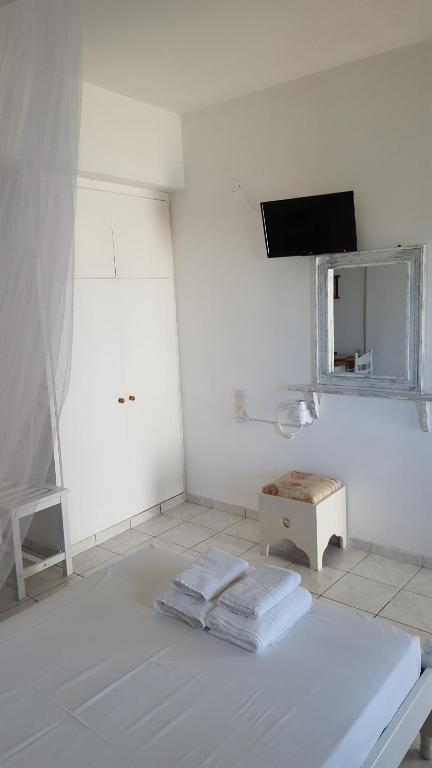 a white room with a bed and a mirror at Aeolos Hotel Apartments in Gythio