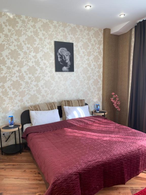 1 dormitorio con 1 cama grande con manta roja en Most City Riverview en Dnipró