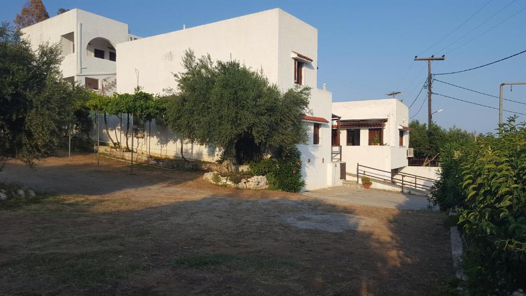 a white house with a yard in front of it at Aeolos Hotel Apartments in Gythio