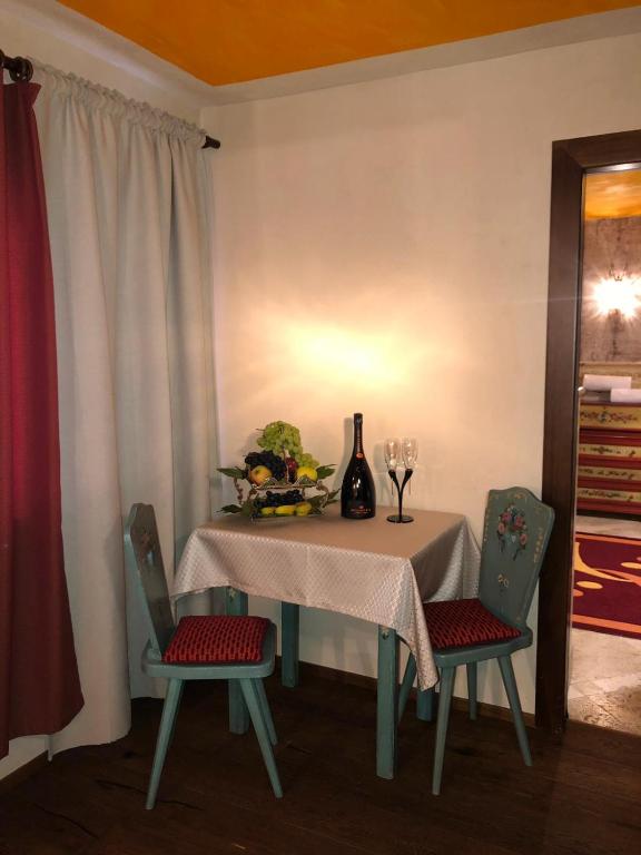 a table with two chairs and a vase on it at Hotel Punta Maquignaz in Breuil-Cervinia