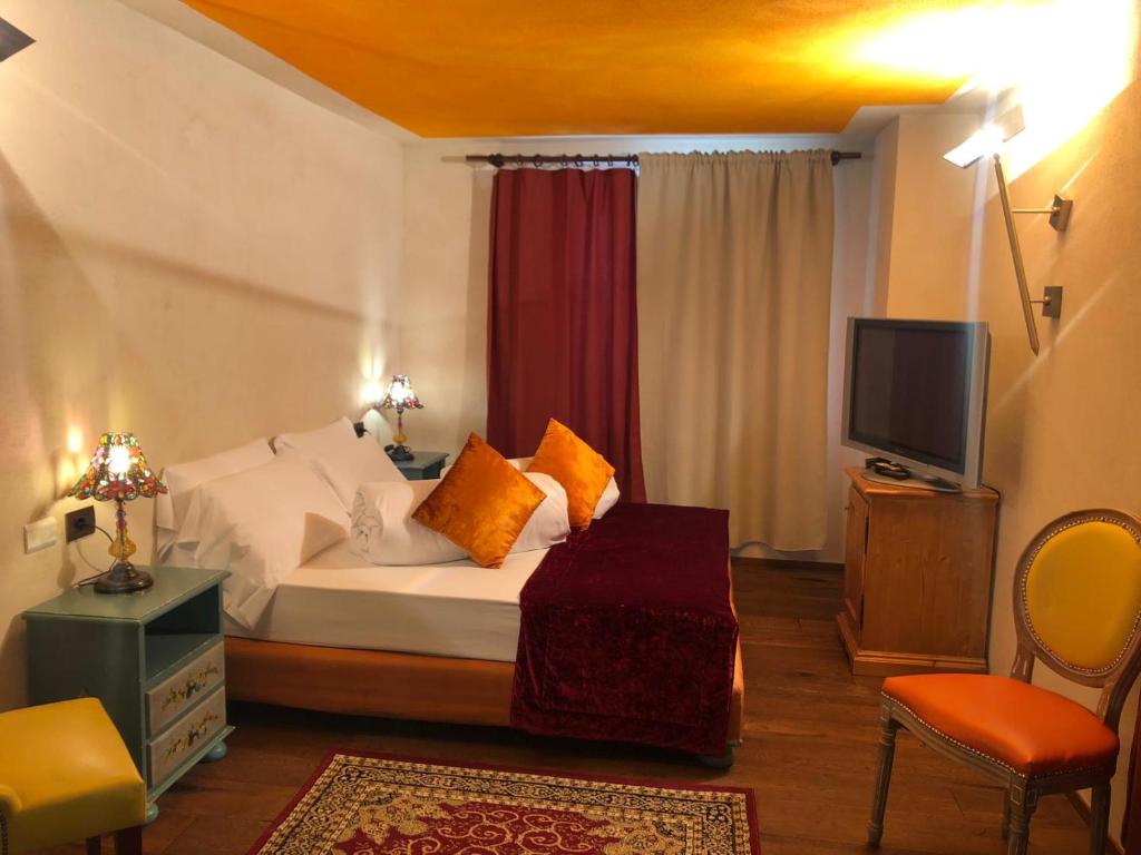 a hotel room with a bed and a tv at Hotel Punta Maquignaz in Breuil-Cervinia