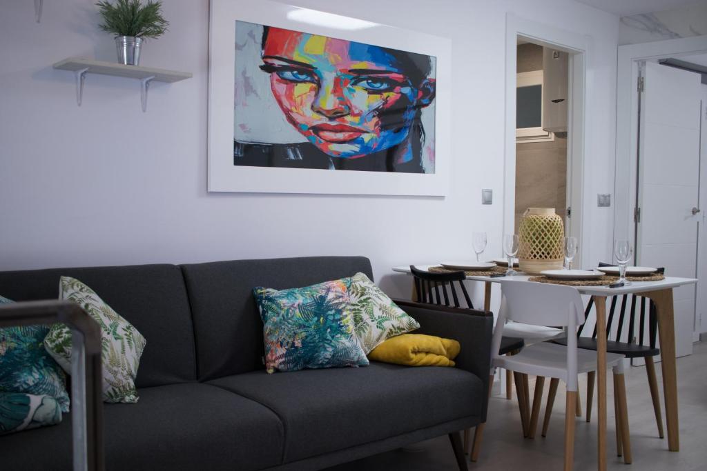 贝尼多姆APARTAMENTO EN EL CENTRO A UN MINUTO DE LA PLAYA的客厅配有沙发和带绘画的桌子