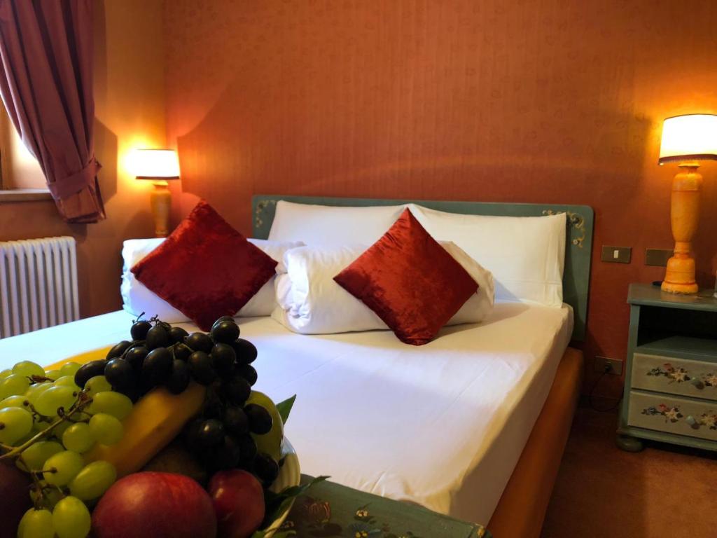 a bedroom with a bed with a bunch of fruit on it at Hotel Punta Maquignaz in Breuil-Cervinia
