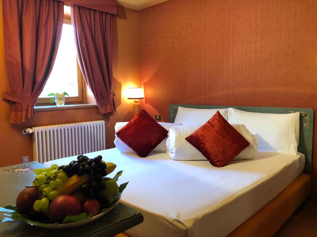 a bedroom with a bed with a bowl of fruit on a table at Hotel Punta Maquignaz in Breuil-Cervinia