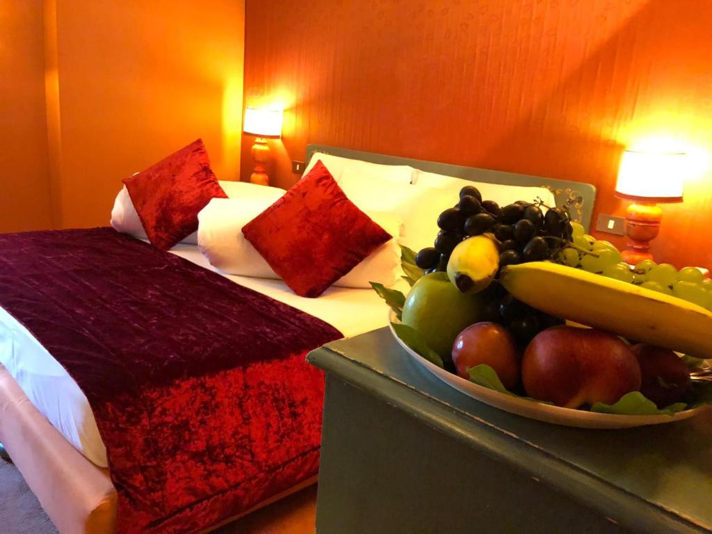 a bowl of fruit on a table next to a bed at Hotel Punta Maquignaz in Breuil-Cervinia