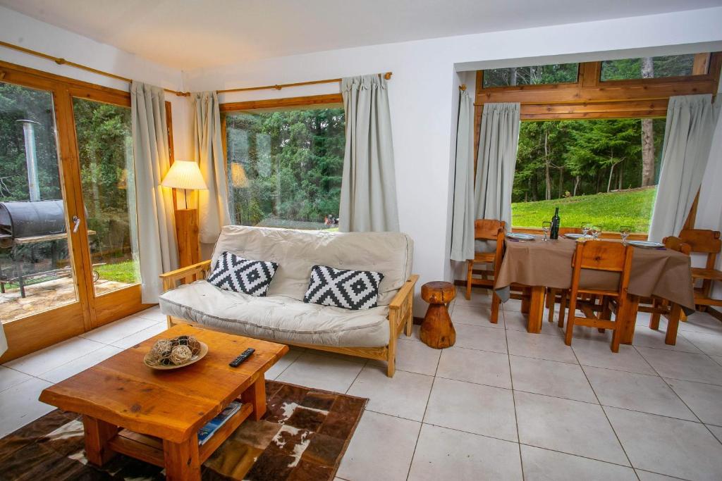 een woonkamer met een bank en een tafel bij Cabañas Villa Sequoia in Bariloche