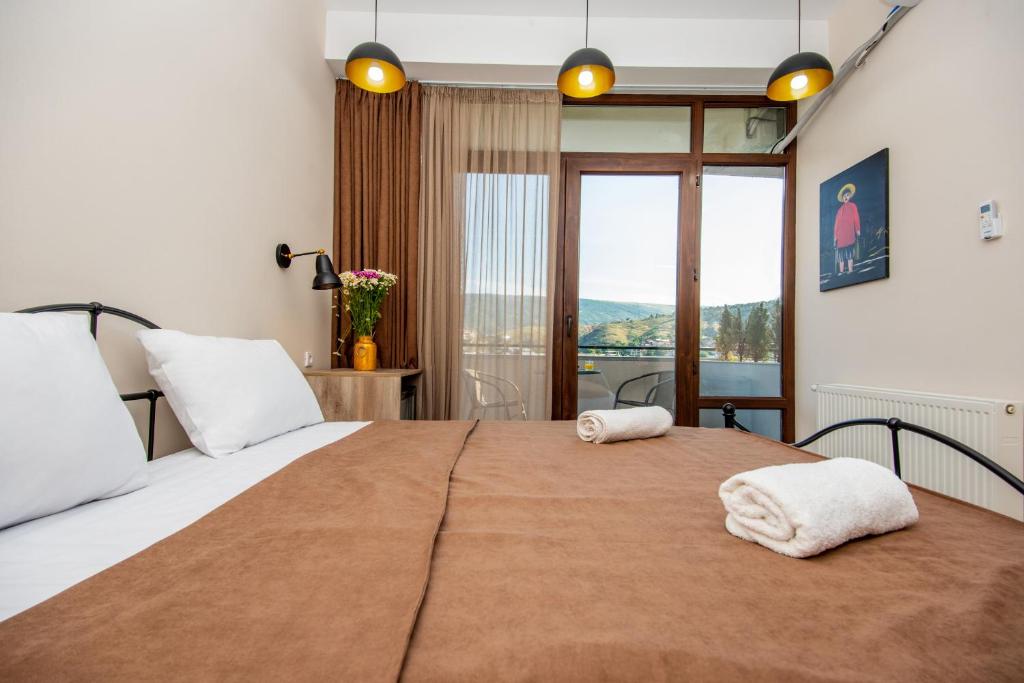 a bedroom with a large bed with two towels on it at Tonusi Luxe Hotel in the Historic City Center in Tbilisi City