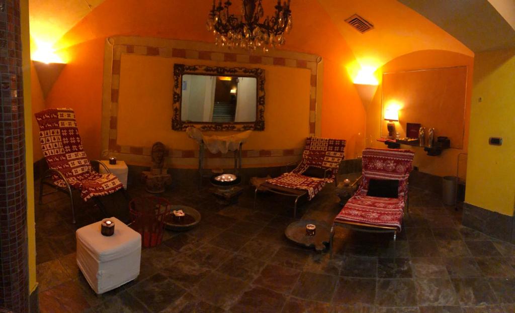a living room with chairs and a mirror at Hotel Punta Maquignaz in Breuil-Cervinia