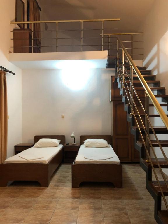 duas camas num quarto com uma escada em Apartments Toni em Ulcinj