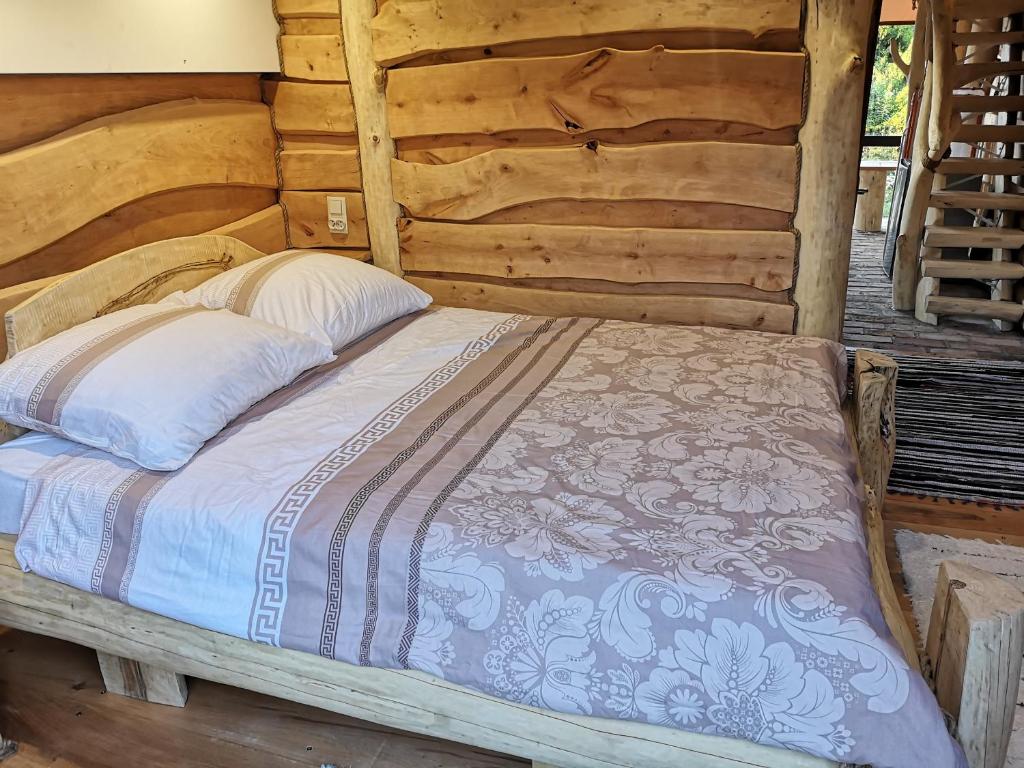 1 cama en una habitación en una cabaña de madera en Olszynowy Zakątek -Mała magia en Augustów