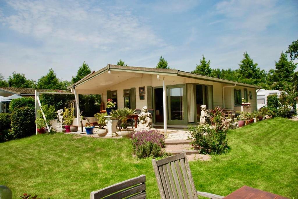 een huis met een tuin met stoelen en planten bij Villa Pantano in Berkhout