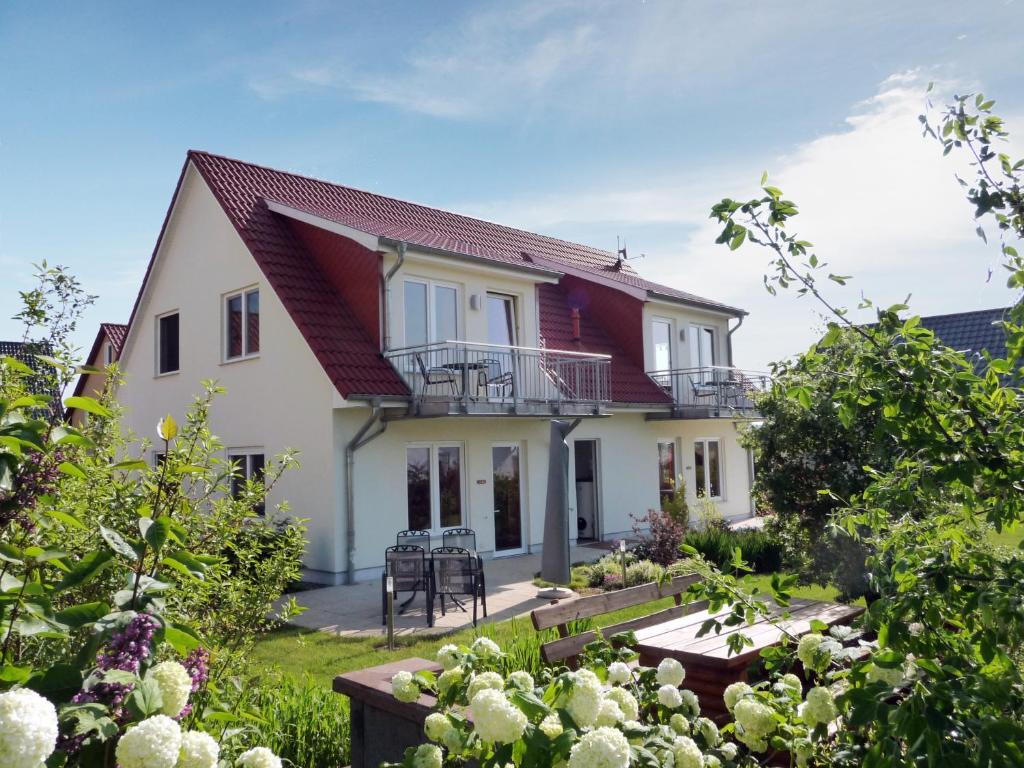 a white house with a red roof at Usedom Ferienwohnungen Tannengrund in Loddin