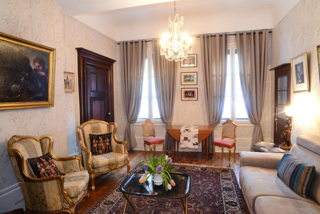 un soggiorno con divano, sedie e tavolo di Benigne Malyon a Digione