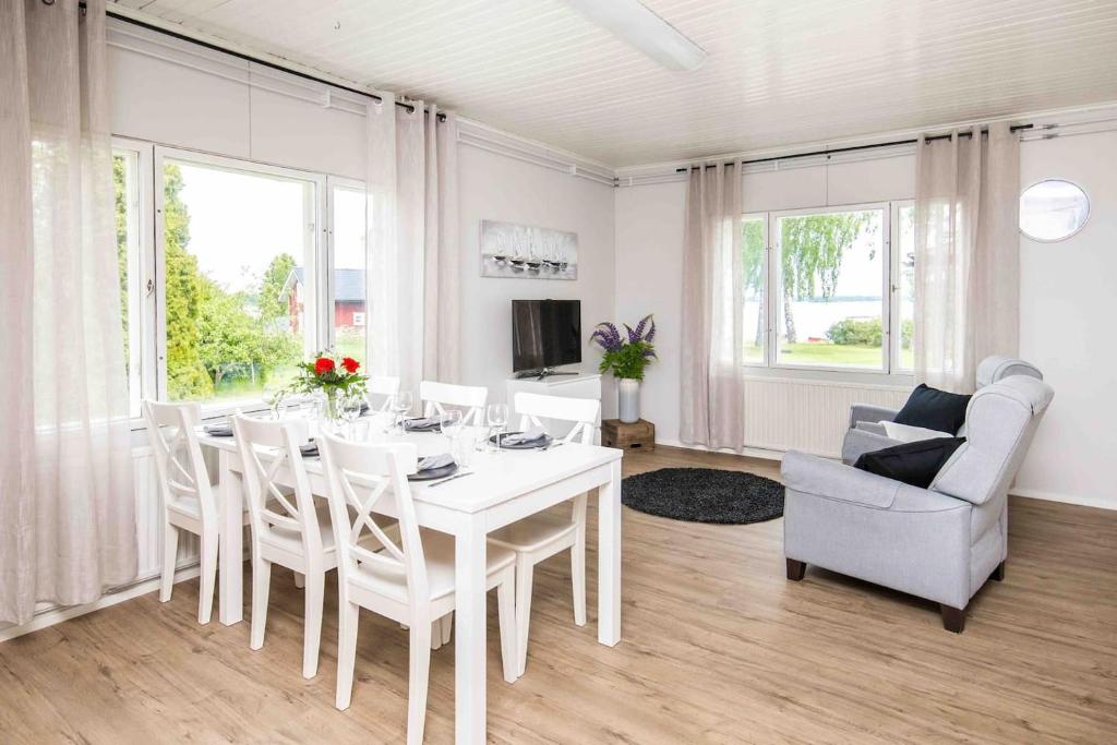 a white dining room with a white table and chairs at Villa Sjöman - with seaview in Alskat