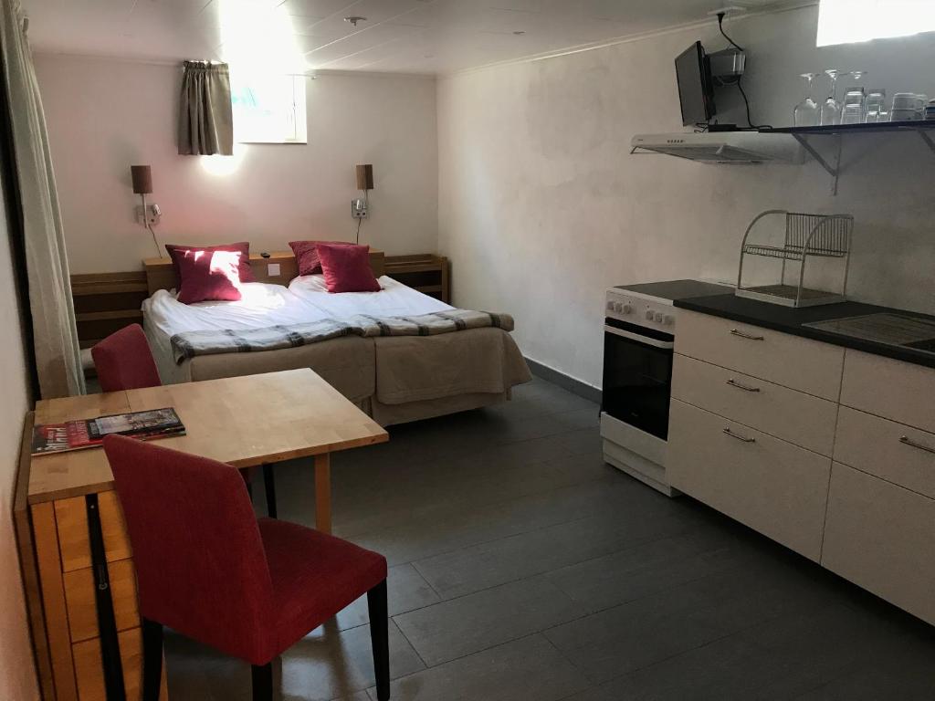 Habitación pequeña con cama, mesa y cocina en Byxelkrok, Solis en Byxelkrok