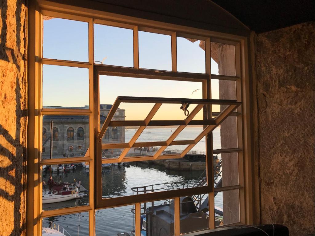 une fenêtre ouverte avec vue sur l'eau dans l'établissement Royal William Yard Apartment, à Plymouth