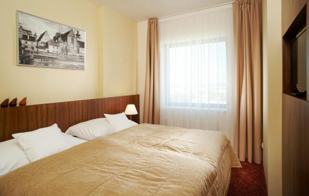 a bedroom with a bed and a window at Clarion Congress Hotel České Budějovice in České Budějovice