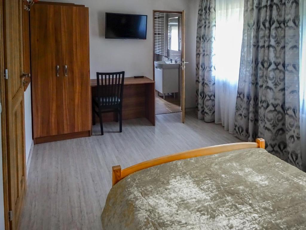 ボルクフにあるPokoje Gościnne Bolkówのベッドと机と椅子のある寝室