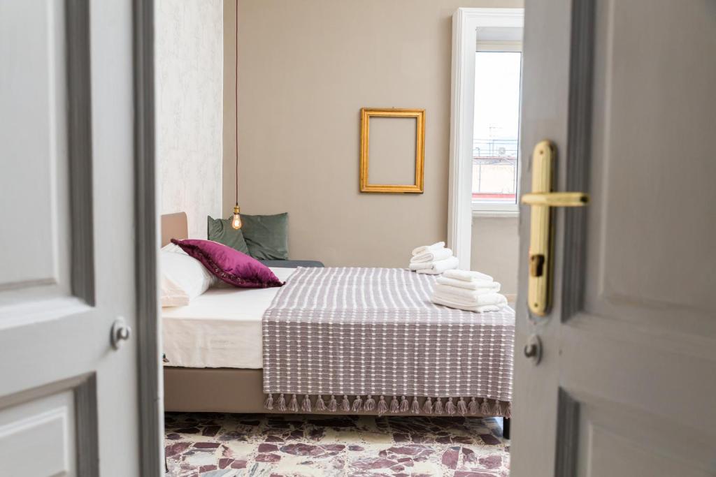a small bedroom with a bed and a window at N'Art Suites - Napoli in Naples