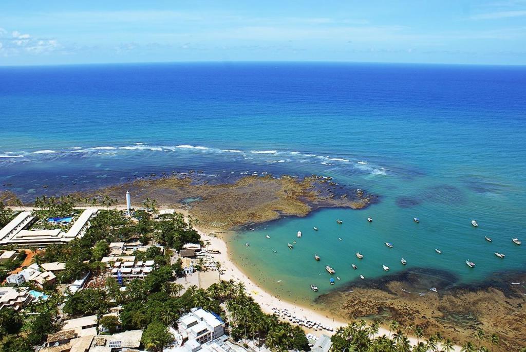 an aerial view of a beach with boats in the water at Praia do Forte Suites in Praia do Forte