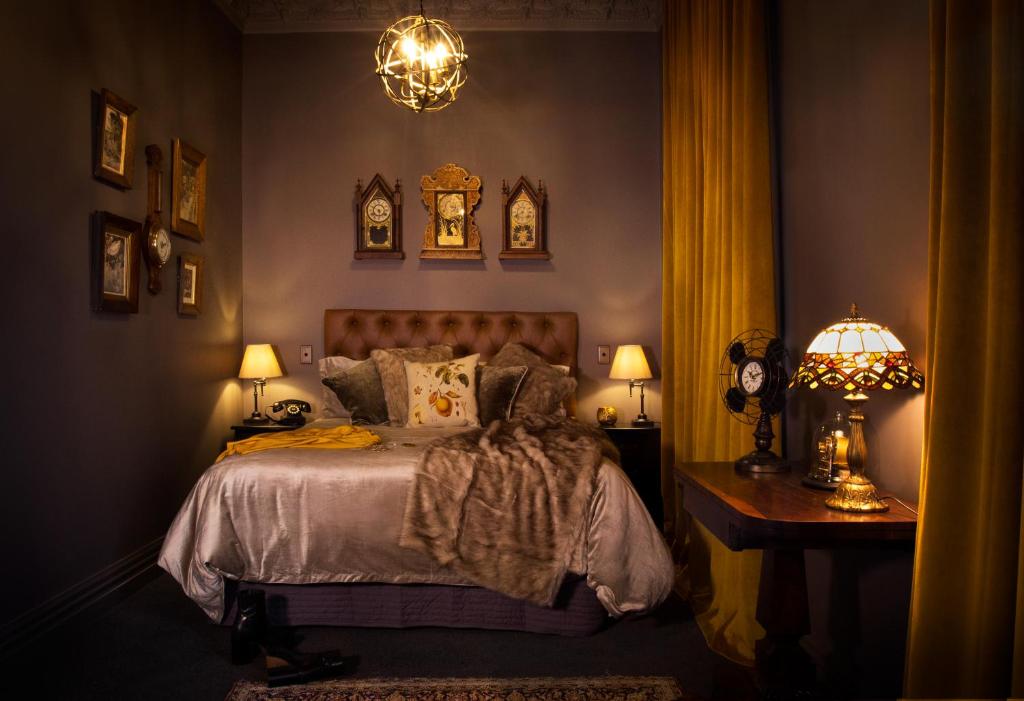 a bedroom with a bed and two lamps and a table at The Royal Hotel Featherston - Boutique Hotel in Featherston