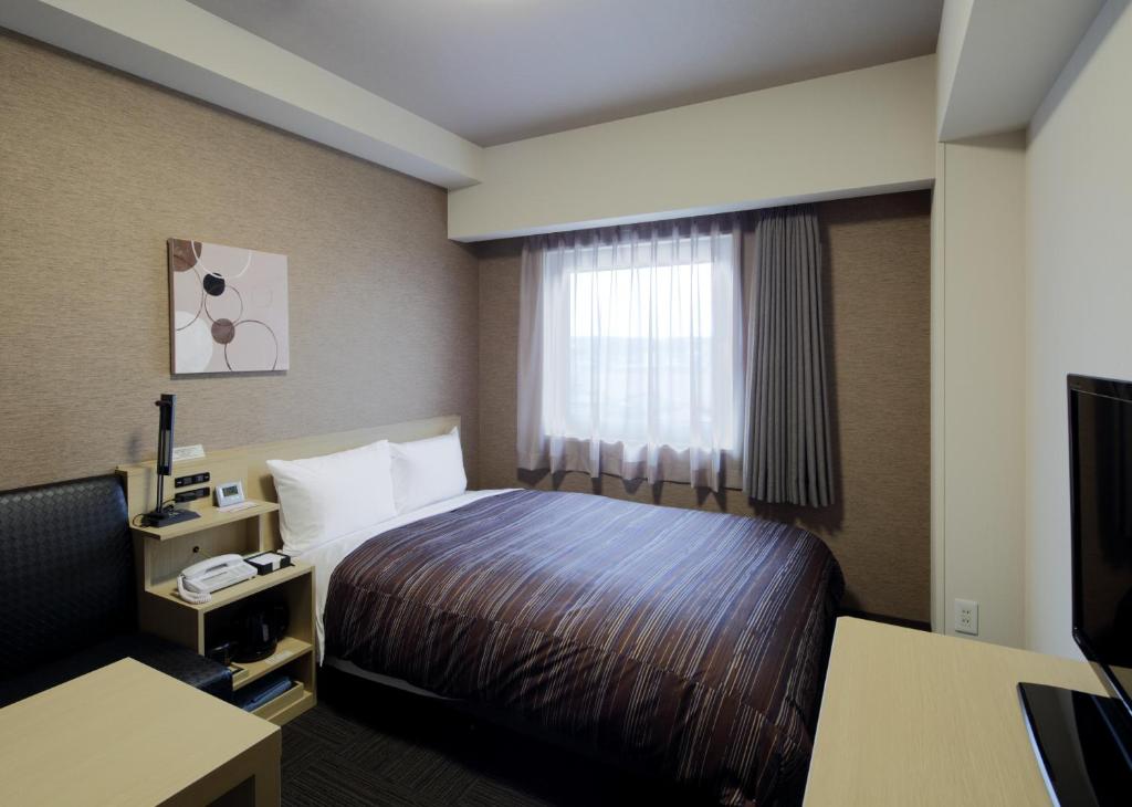Postel nebo postele na pokoji v ubytování Hotel Route-Inn Kashiwa Minami -Kokudo 16Gouzoi-
