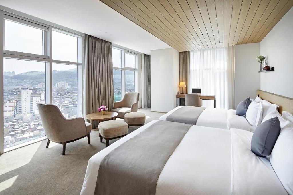 a hotel room with a large bed and windows at MD HOTEL DOKSAN - Fomerly Staz Hotel Doksan in Seoul